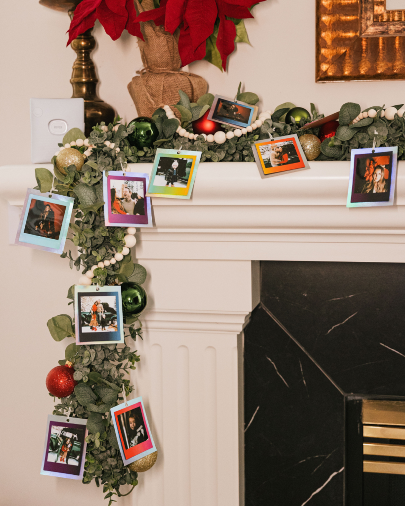 instax™ prints hanging in garland on the fireplace