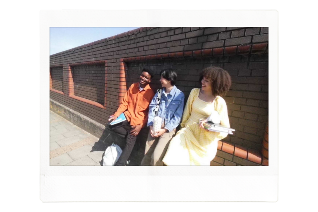 instax™ WIDE print of three friends laughing whilst sat on a wall